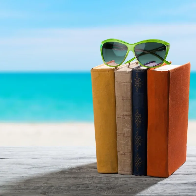 Livres et lunettes de soleil sur fond de plage